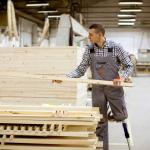 Disabled man with artifical leg working in a furniture factory